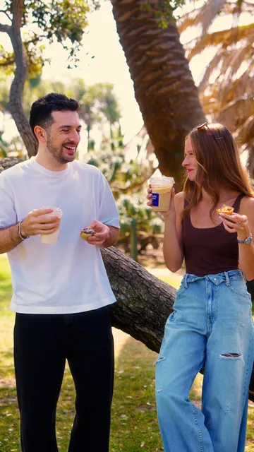 Two people enjoying Mostly Sunny natas and iced coffee outdoors